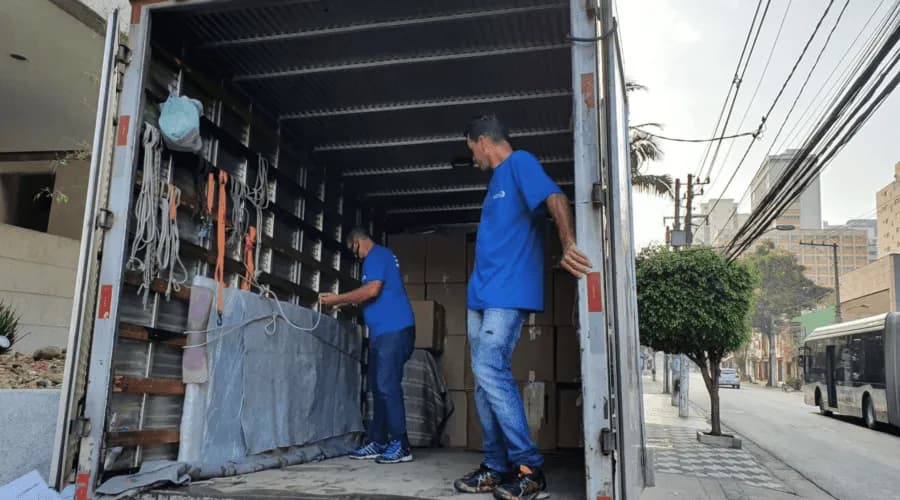 Equipe organizando carga no caminhão.